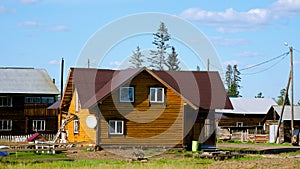 A new private cottage of yellow logs, among the old village houses, is being completed in the summer in Yakutia in the village