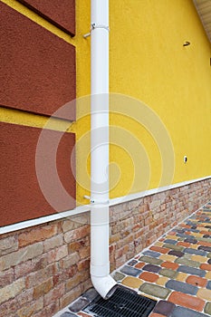 New rain gutter on yellow wall.