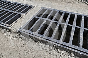 New rainwater grate on the road or sidewalk, installation in concrete. City sewage system for draining water during heavy rain