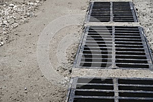 New rainwater grate on the road or sidewalk, installation in concrete. City sewage system for draining water during heavy rain