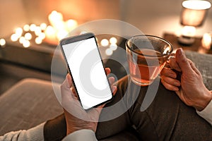 New reading technology using smartphone to enjoying preferred ebook: close up of unrecognizable woman sitting on sofa holding a
