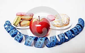 New real diet concept, question sign in shape of measurment tape between red apple and donut isolated on white