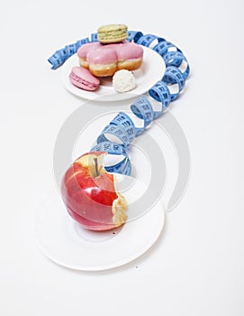 new real diet concept, question sign in shape of measurment tape between red apple and donut isolated on white