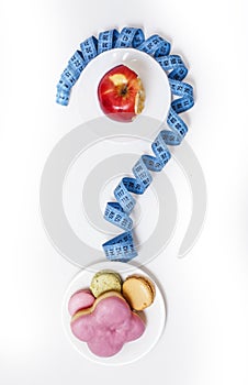 new real diet concept, question sign in shape of measurment tape between red apple and donut isolated on white