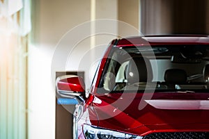 New red luxury SUV compact car parked in modern showroom for sale. Car dealership office. Car retail shop. Electric and hybrid car