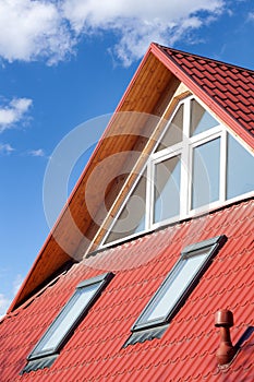 New red metal roof with attic windows skylights and Ventilation pipe for heat control. photo