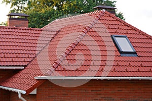 New Red Shingles Roof with Skylights Windows and Rain Gutter. New brick house with chimney