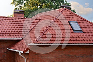 New Red Shingles Roof with Skylights Windows and Rain Gutter. New brick house with chimney