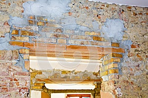 New reinforced brick lintel useful for creating a new door, or a new window, in an old stone and brick wall in a construction site