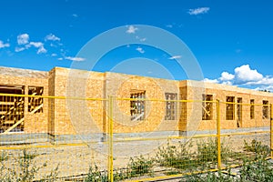 New residential building under construction with metal fence in front