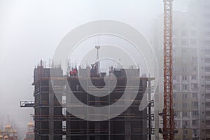 A new residential building under construction in the morning mist.