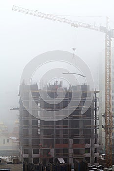 A new residential building under construction in the morning mist.