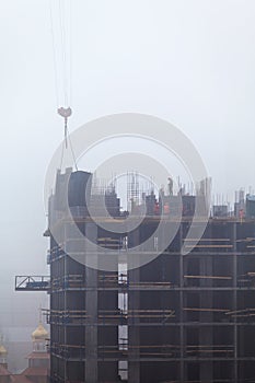 A new residential building under construction in the morning mist.