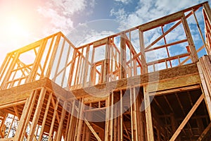 New residential construction home framing against a blue sky.