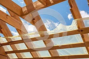 New residential construction home framing against a blue sky. Roofing construction. Wooden construction.