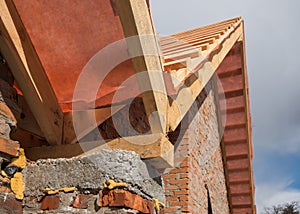 New residential construction home framing and installation of wooden beams at the roof truss system and vapor barriers.