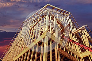 New residential construction house framing against a sunset