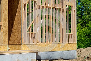 The new residential construction showcases impressive house framing against a clear blue sky and lumber planks