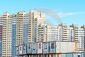 New residential multi-storey buildings, before them barracks for builders trailers. The concept of urbanization, contrast.