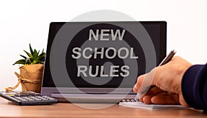 New school rules symbol. Tablet with words `New school rules`. Online education during COVID-19 quarantine. Male hand with pen, photo