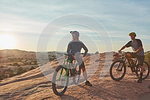 New set of wheels, new set of goals. Full length shot of two young male athletes mountain biking in the wilderness.