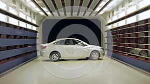 New shite car is rotating around itself inside wind tunnel for vehicle testing