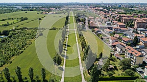 New Skyline of Milan seen from the Milanese hinterland, aerial view, tree lined avenue. Pedestrian cycle path