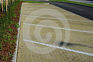 New sloping parking space with drawn lines and symbols for parking wheelchair users and people with disabilities. flowerbed with h