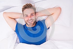 New smile, new day. Happy man awaken in bed. Handsome caucasian man with happy smile relaxing in the morning. Sparkling