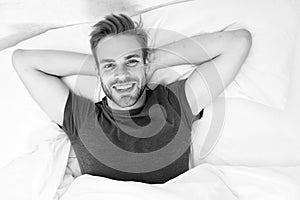 New smile, new day. Happy man awaken in bed. Handsome caucasian man with happy smile relaxing in the morning. Sparkling