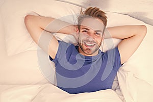 New smile, new day. Happy man awaken in bed. Handsome caucasian man with happy smile relaxing in the morning. Sparkling