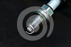 New spark plug on dark background, selective focus