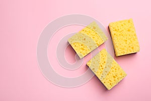 New sponges on pink background, flat lay. Space for text