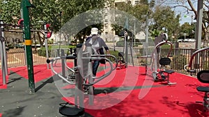 New sport training complex in the courtyard of a multi-story building. Woman on the simulator