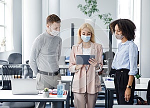 New task, social distancing and office work after lockdown. Young business woman with protective mask gives tasks to