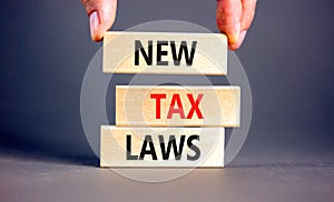 New tax laws symbol. Concept words New tax laws on wooden blocks on a beautiful grey table grey background. Businessman hand.