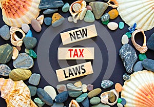 New tax laws symbol. Concept words New tax laws on wooden blocks on a beautiful black table black background. Sea stone, sea shell