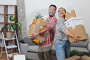 New Tenant Life: Young couple tenants, with cardboard relocation boxes, new apartment& x27;s living room