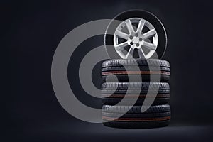 New tires pile on a dark background. Tire fitting background.