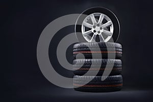 New tires pile on a dark background. Tire fitting background. photo