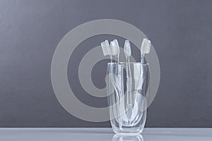 New Toothbrush in glass on gray