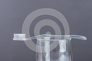 New Toothbrush in glass on gray