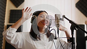 New Track. Energetic Asian Female Singer Recording Song In Music Studio