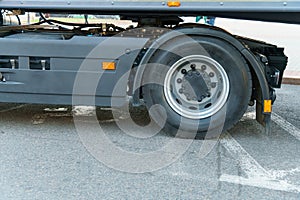 A new truck with a trailer on the road. Details of the truck in close-up. New headlights and wheels of the car. The concept of