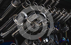 New and used motorcycle exhaust chrome pipes in a motorcykles shop or in service center.