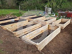 new vegetable garden built with raised wooden beds with fertile soil to cultivate