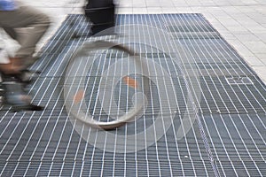 New ventilation iron grid in an urban area with a cyclist passing