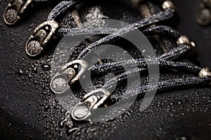 A new waterproof leather trekking hiking winter boot with water drops on black background closeup