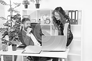 New ways to automate business processes. Managers work in modern office. Bearded man and sexy woman use laptop. Using