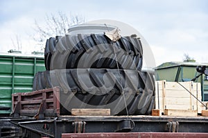 New wheel tyres for farm tractors and agriculture machinery being shipped on rails on freight train.